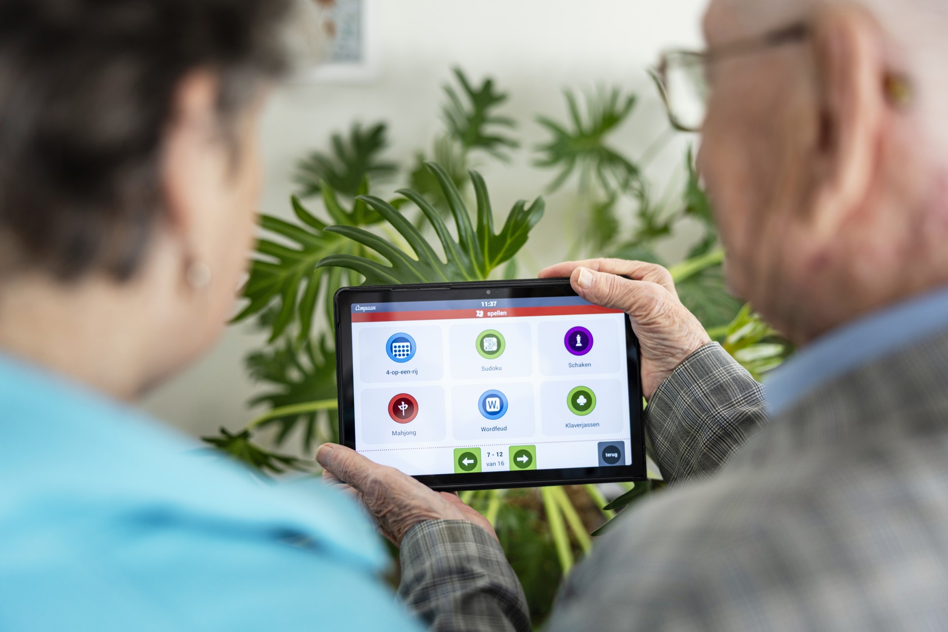 Twee senioren gebruiken een seniorentablet.